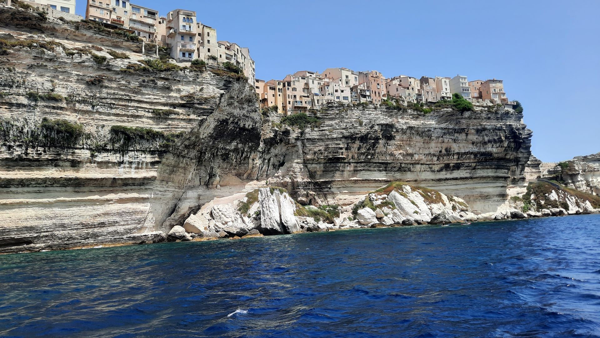 Experience Bonifacio from the sea on Day 3 of our Corsica, France trip. Sail past majestic cliffs, sea caves, and the famous hanging houses on a peaceful boat tour.